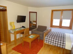 a bedroom with a bed and a chair and a desk at Apartment 116 in Jahorina