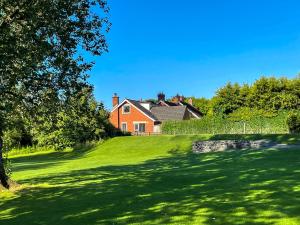 une maison sur une colline avec une cour verte dans l'établissement Fairway House, à Carrickfergus