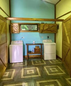 a small bathroom with two washers and a table in it at Above the Gulf, Vacation House in Monteverde Costa Rica