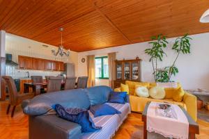 Una sala de estar con un sofá azul y una cocina. en Apartments Ozren, en Omiš