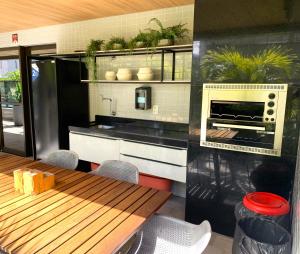une cuisine avec une table en bois et un four dans l'établissement Ponta Verde 250m praia I Feirinha do Artesanato I Piscina I Academia, à Maceió