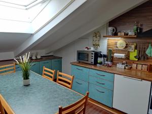 a kitchen with blue cabinets and a table with chairs at Loft Mansardato in Monza