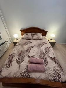 Una cama en un dormitorio con dos lámparas y dos toallas. en Maghy Appart à Strasbourg, en Estrasburgo