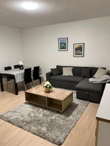 una sala de estar con un sofá y una mesa en Maghy Appart à Strasbourg, en Estrasburgo