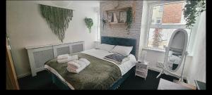 Un dormitorio con una cama con toallas. en The Hideaway Cottage Feel Patio Central Parking, en Southport