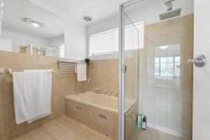 a bathroom with a shower and a tub and a sink at Sapphire by the Sea - Beach Family Modern in Grange +19 photos