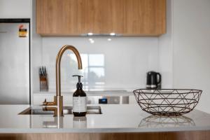 a kitchen counter with a sink and a bottle of wine at Oceanside Retreat Mt Maunganui in Mount Maunganui +11 photos