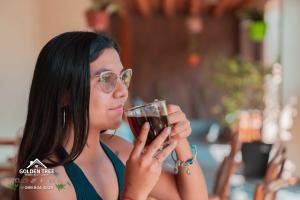 a woman with glasses holding a glass of wine at GOLDEN TREE MINDO ECO-LODGE in Mindo