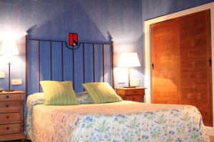 a bedroom with a bed and a lamp at El Hotel De La Villa in Pedraza-Segovia