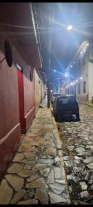 a car parked on the side of a street at night at Paradise Hospedaria São Thomé in São Thomé das Letras