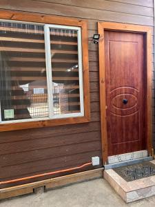 a wooden door on the side of a house at Cabaña en puerto natales in Puerto Natales