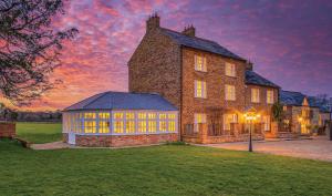 a large brick building with yellow windows in a yard at Hardwick Lodge in Wellingborough