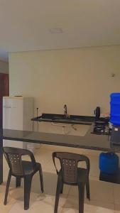 a kitchen with two chairs and a counter top at Aparecida apartamento Rone 3 in Aparecida +1 photo