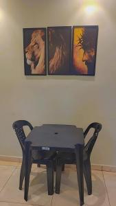 a black table in a room with four pictures on the wall at Aparecida apartamento Rone 3 in Aparecida