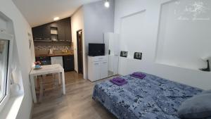 a bedroom with a bed and a small kitchen at Molders Apartments in Belgrade