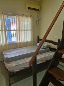 une chambre avec deux lits superposés et une fenêtre dans l'établissement Casa Azul de Itaguaçu, à São Francisco do Sul