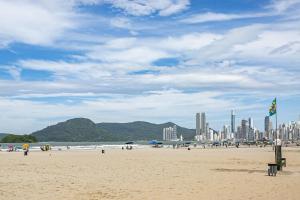 a group of people on a beach with a city at Apto na avenida atlântica in Balneário Camboriú