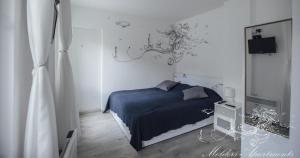 a bedroom with a blue bed and a chandelier at Molders Apartments in Belgrade