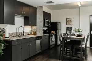 ロサンゼルスにあるOasis in heart of Hollywoodの黒いキャビネットとカウンター付きのテーブルを備えたキッチン