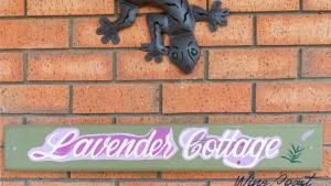un panneau sur le côté d'un mur de briques dans l'établissement Lavender Cottage By Wine Coast Holidays, à Aldinga Beach