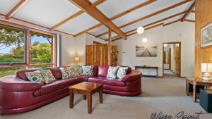 - un salon avec un canapé en cuir rouge dans l'établissement Lavender Cottage By Wine Coast Holidays, à Aldinga Beach