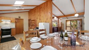 une cuisine et une salle à manger avec une table avec des verres à vin dans l'établissement Lavender Cottage By Wine Coast Holidays, à Aldinga Beach