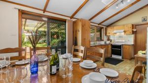 une cuisine et une salle à manger avec une table avec des verres à vin dans l'établissement Lavender Cottage By Wine Coast Holidays, à Aldinga Beach 14 autres photos
