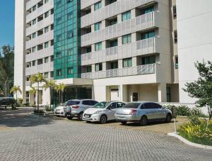 een rij auto's geparkeerd voor een gebouw bij Flat completo próximo ao Rio centro e Arena Carioca in Rio de Janeiro