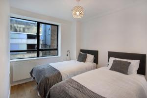 2 camas en un dormitorio con ventana en 2-Bed Apartment Sleeps 4 Free Parking, en Croydon