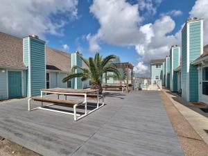 un paseo marítimo con dos bancos y una palmera en Canal Views & Pool Minutes to Beach Fishing Pier, en Padre Island
