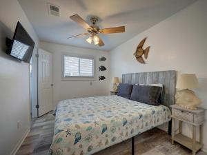 Un dormitorio con una cama y un ventilador de techo. en Canal Views & Pool Minutes to Beach Fishing Pier, en Padre Island