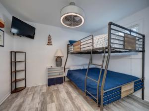 Un dormitorio con dos literas y un televisor. en Canal Views & Pool Minutes to Beach Fishing Pier, en Padre Island