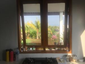 a kitchen window with a view of a garden at Geyu House in Jembrana
