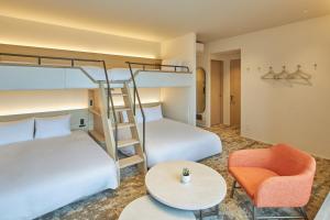 a bedroom with two bunk beds and a table and a chair at FAV LUX Kagoshima Tenmonkan in Kagoshima