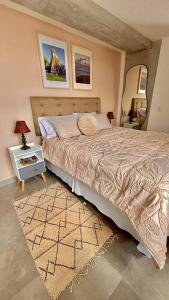 a bedroom with a bed and a table with a lamp at Wanderer estilo boho chic in Las Victorias