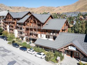 una vista aérea de un lodge con coches aparcados en un aparcamiento en Apartment in France near the Alps, en La Toussuire