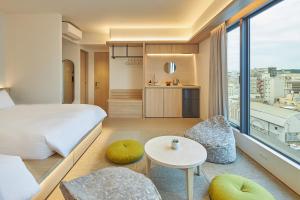 a hotel room with a bed and a table and chairs at FAV LUX Kagoshima Tenmonkan in Kagoshima