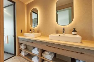 two sinks in a bathroom with two mirrors at FAV LUX Kagoshima Tenmonkan in Kagoshima