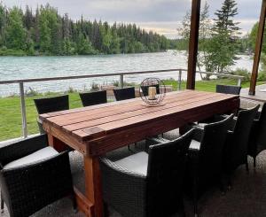 a wooden table and chairs with a view of the water at Kenai Living Waters - Fishing Paradise in Sterling +26 photos