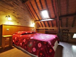 a bedroom with a bed with a red comforter at Gîte paisible en parc arboré, 3 ch., prox. Nantes/Rennes, équipements bébé, activités plein air - FR-1-306-1115 in Nozay