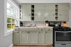 a kitchen with white cabinets and a sink at The Cardinal in Newburgh +7 photos