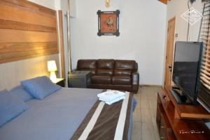 a bedroom with a bed and a couch and a television at Terra Volcán in Victoria