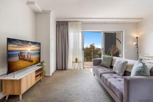 卡瓦纳华特斯Birtinya 1-Bed with Canal Views and Pool的带沙发和电视的客厅