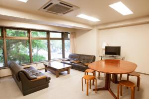 a living room with a table and a couch at Seto Park Hotel in Seto