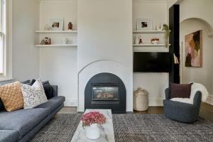 ein Wohnzimmer mit Couch und Kamin in der Unterkunft Luxe cottage in the heart of Sandy Bay in Sandy Bay