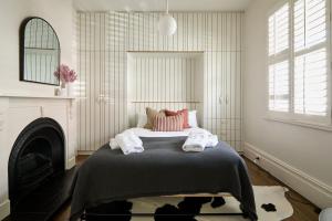 ein Schlafzimmer mit einem Bett mit Handtüchern darauf in der Unterkunft Luxe cottage in the heart of Sandy Bay in Sandy Bay