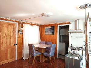 eine Küche mit Tisch und Stühlen und einem Herd in der Unterkunft Cabaña Patagonia Rustica in Coihaique