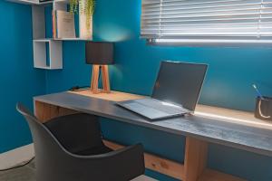 a laptop computer sitting on a desk with a chair at Appartement central, vue panoramique - Madin'Pop 305 in Fort-de-France