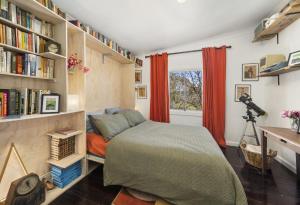 Un dormitorio con una cama y una estantería. en Little Red, en Katoomba