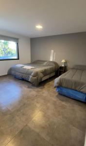 Un dormitorio con dos camas y una ventana. en AIRE MALBEC - Complejo de departamentos, en San Rafael